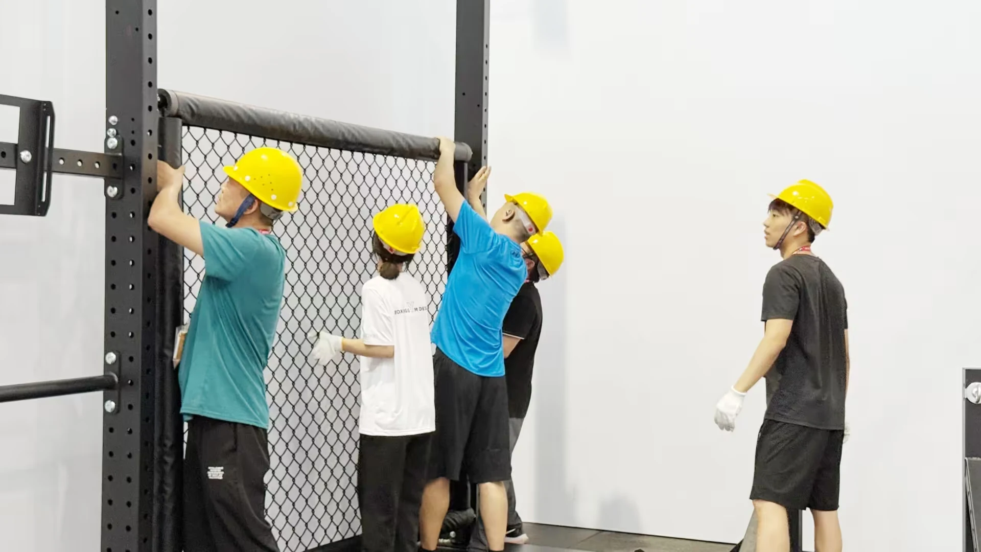 About Our Factory 1 Workers aligning a metal mesh panel during equipment assembly