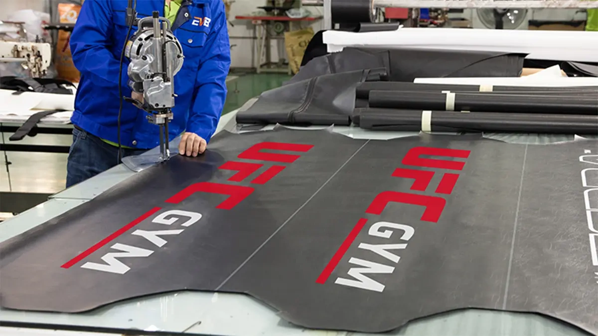 Accueil 8 Branded black material being cut on a workshop table