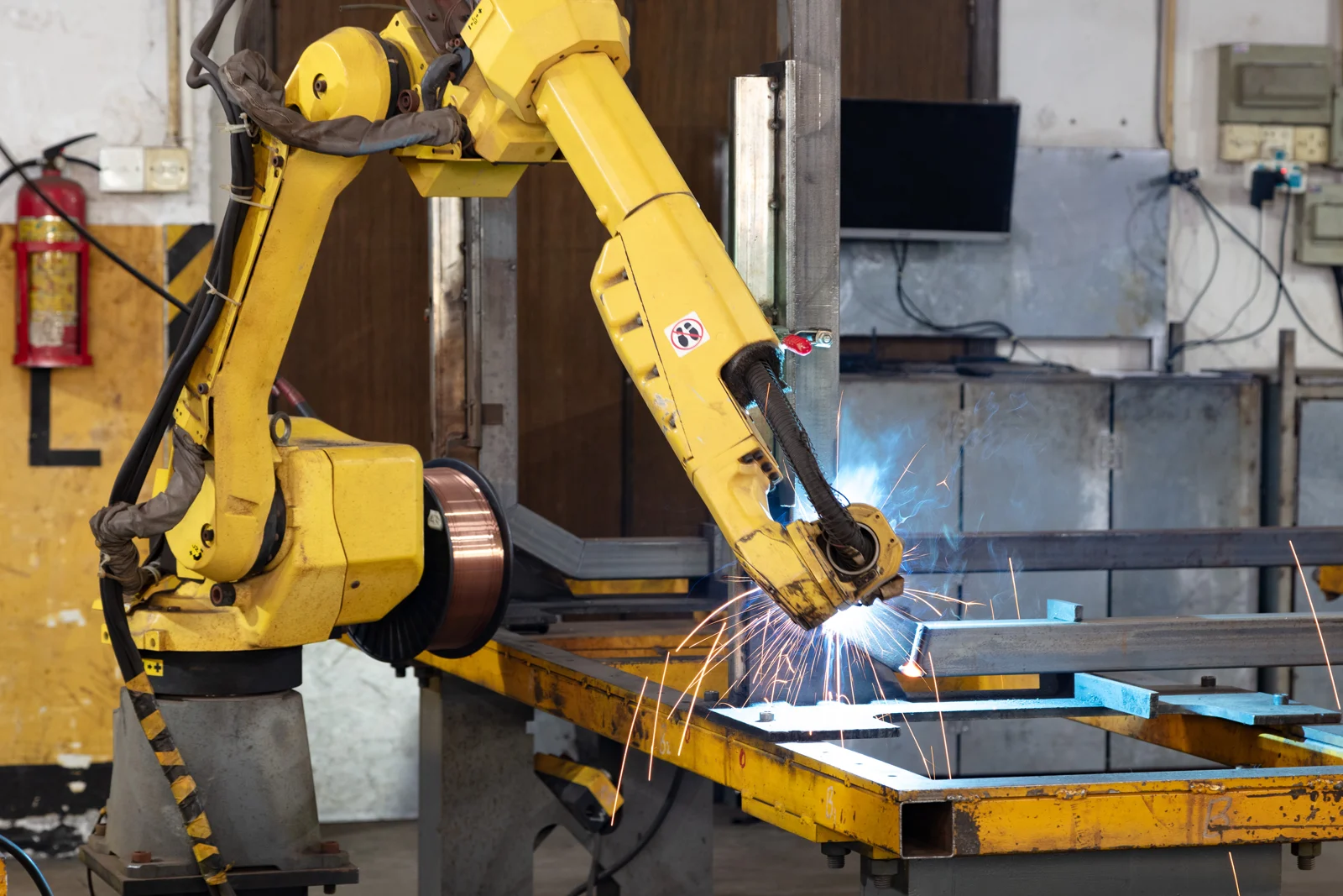 Industrial robot welding a metal frame in an archival 2019 workshop photograph