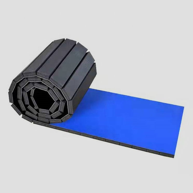 Blue roll-out martial arts mat partly unrolled to show the segmented backing